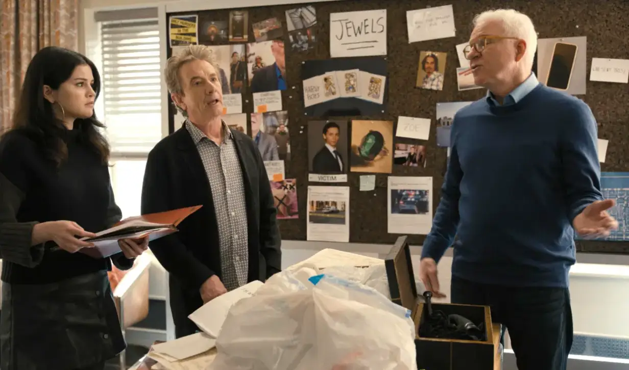 Only Murders in the Building's main characters studying wit a suspect board in the background.